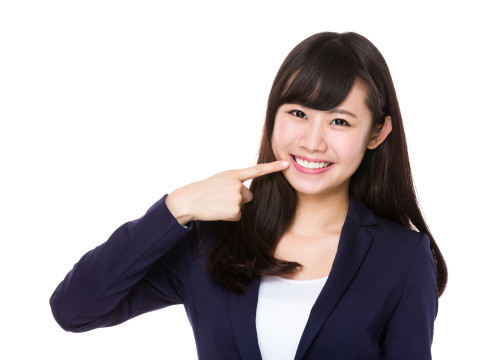 Businesswoman with finger point to her teeth