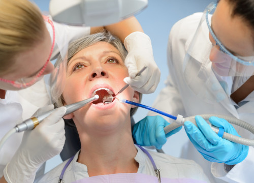 Senior woman patient dental check open mouth professional dentist team